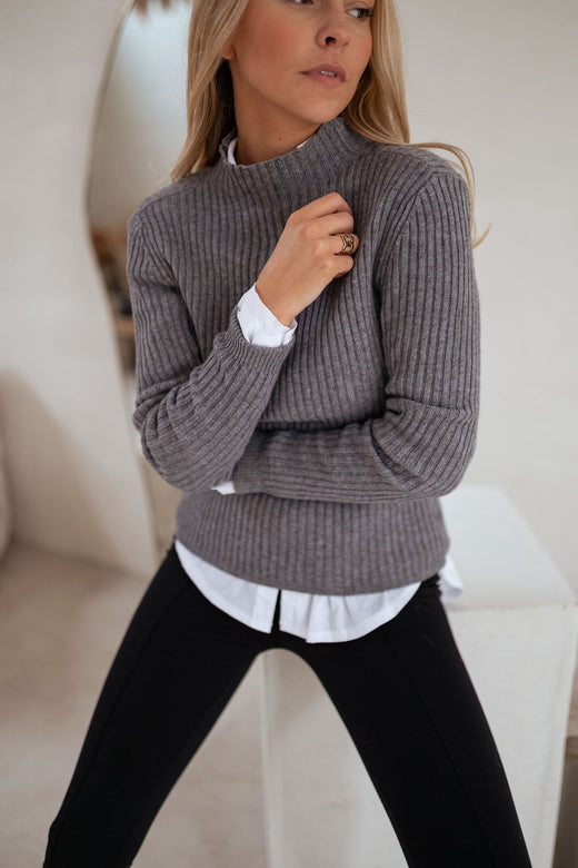 Woman in ribbed turtleneck sweater with leggings